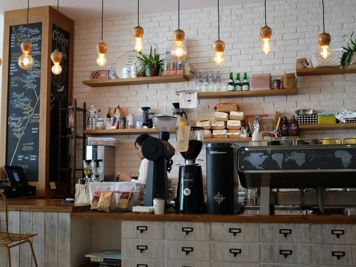 Heller Cafébereich mit Theke, Pendelleuchten und Holztischen