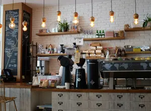 Heller Cafébereich mit Theke, Pendelleuchten und Holztischen