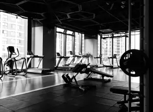 Fitnessstudio mit Trainingsgeräten und großen Fenstern