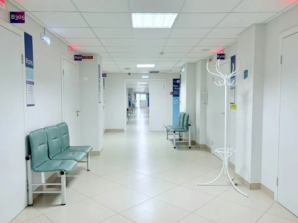 Heller Krankenhausflur mit Türen und Sitzbänken